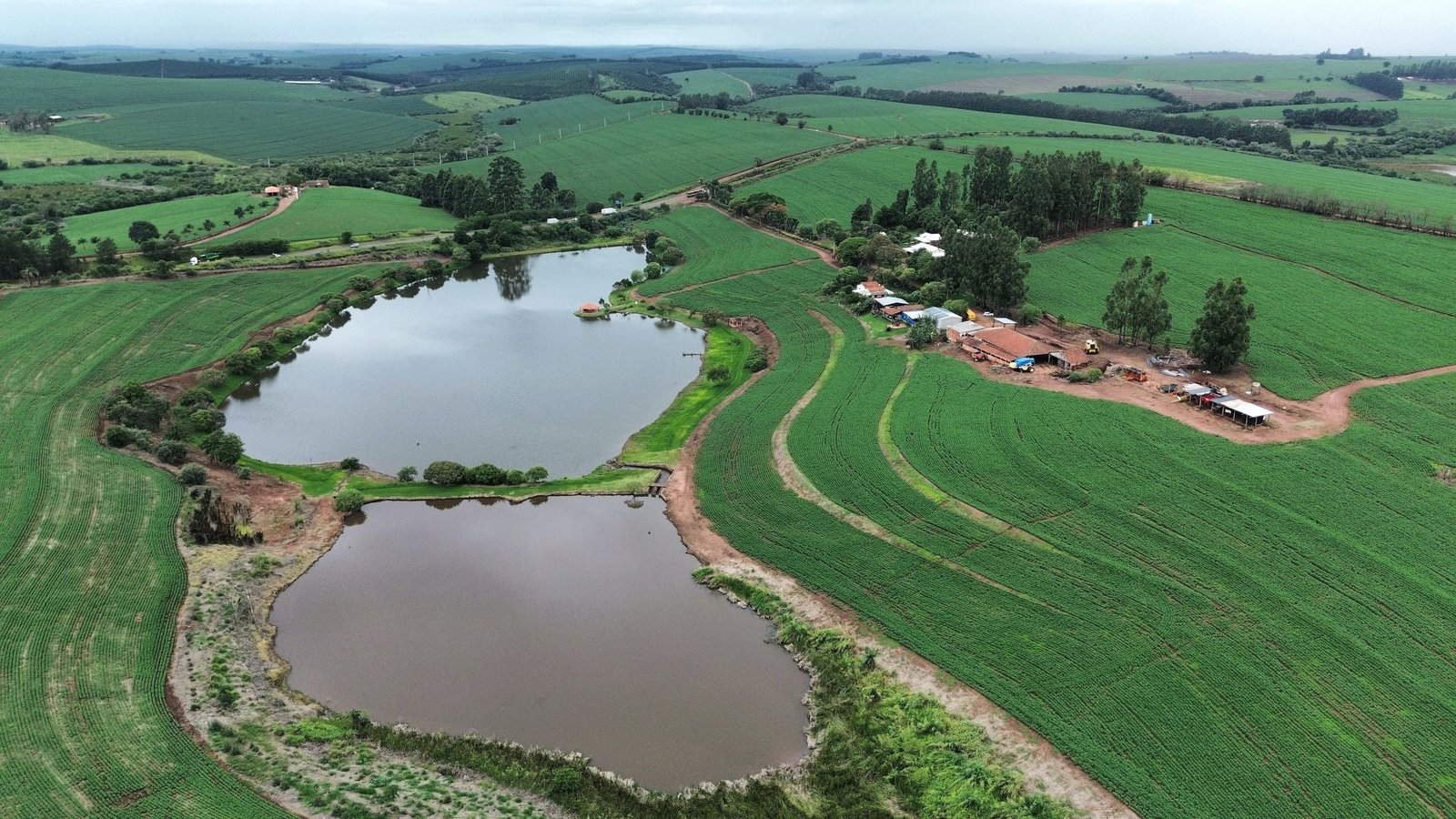 Vista aérea de fazenda com represa e lavoura